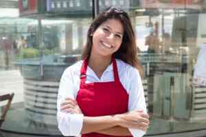 Junge Kellnerin vor dem Restaurant